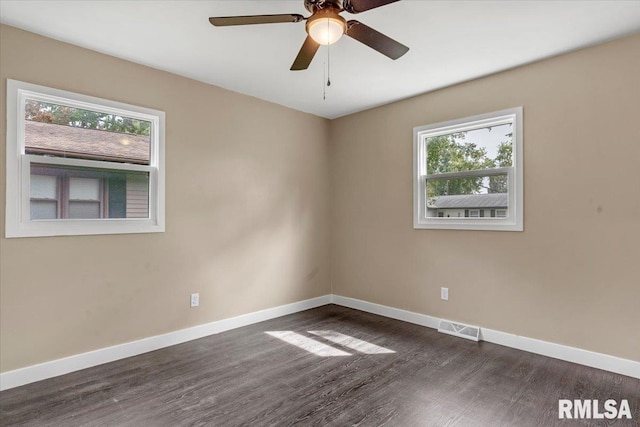 empty room featuring dark wood-type flooring, ceiling fan, and plenty of natural light