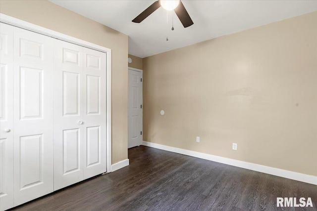 unfurnished bedroom with ceiling fan, a closet, and dark wood-type flooring