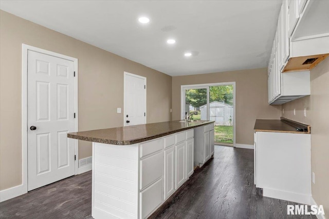 kitchen with sink, dark hardwood / wood-style floors, white cabinetry, and a kitchen island