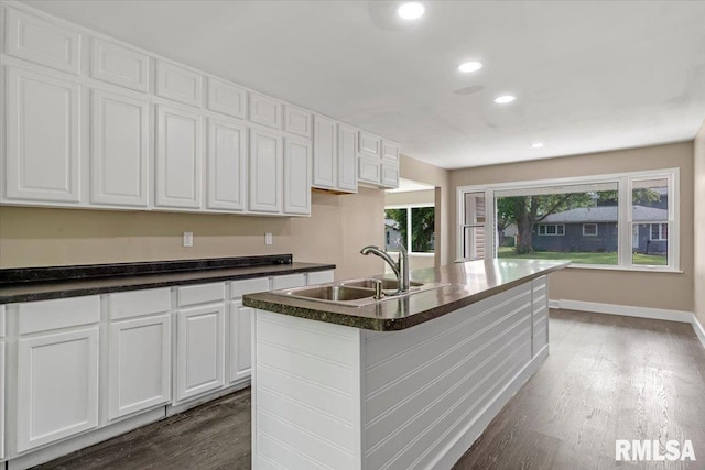 kitchen with white cabinets, a center island with sink, sink, and a wealth of natural light