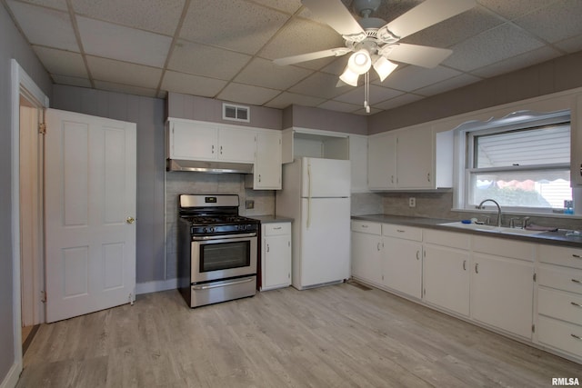 kitchen with white cabinets, white refrigerator, stainless steel range with gas cooktop, ceiling fan, and sink