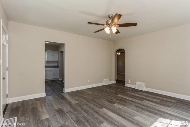 empty room with dark wood-type flooring and ceiling fan