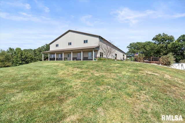 back of house with a lawn and covered porch