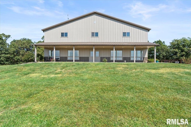 back of property featuring a lawn and covered porch