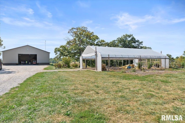 view of yard with a carport and an outbuilding