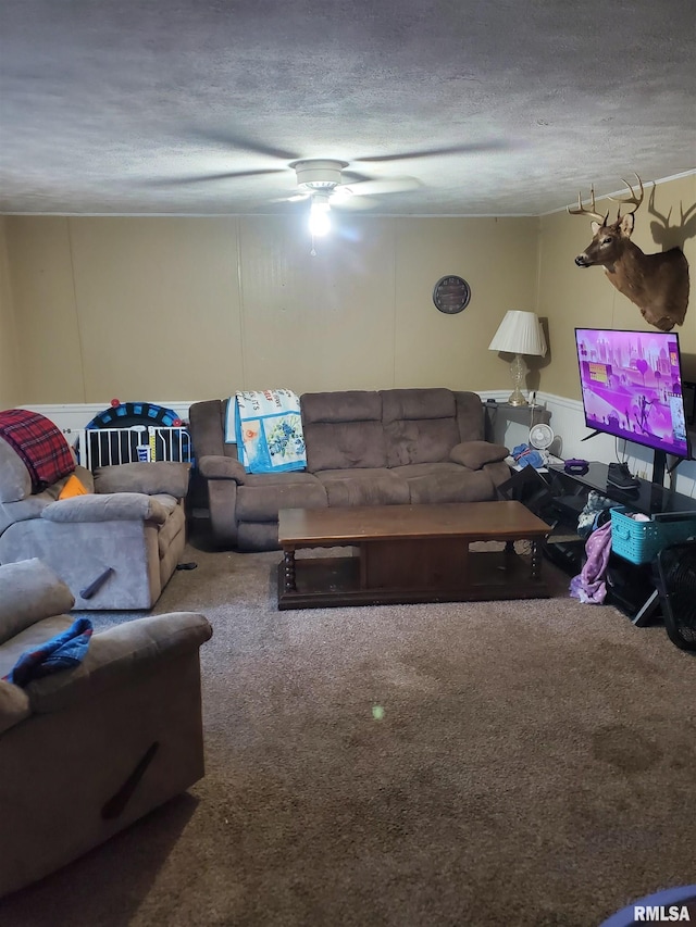 living room with a textured ceiling, carpet, and ceiling fan