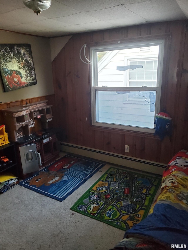 rec room with a baseboard heating unit and wooden walls