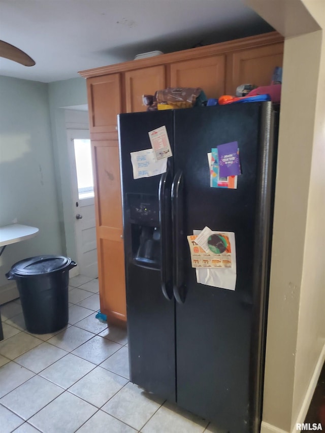 kitchen with light tile patterned floors and black refrigerator with ice dispenser