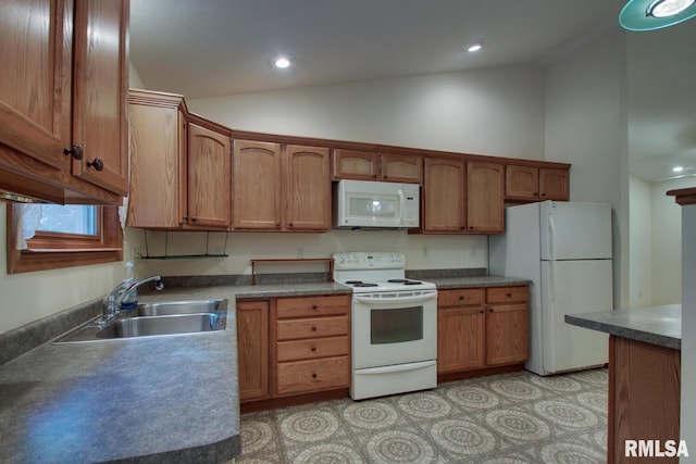 kitchen with white appliances, vaulted ceiling, and sink