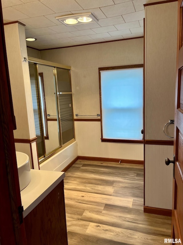 bathroom featuring enclosed tub / shower combo, vanity, and hardwood / wood-style flooring