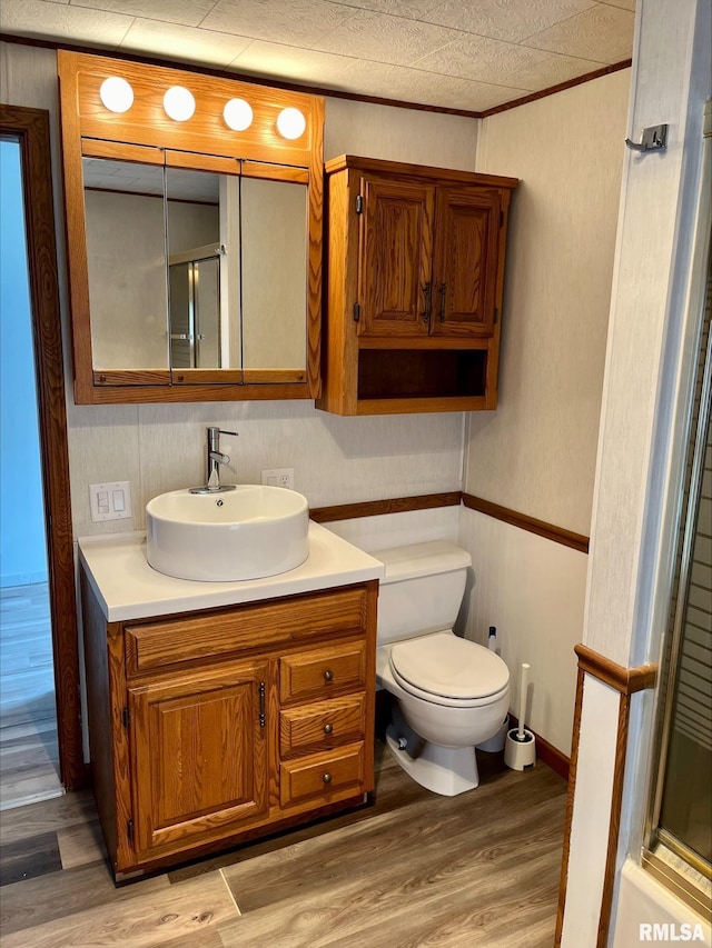 full bath with wood finished floors, toilet, a shower with door, and vanity