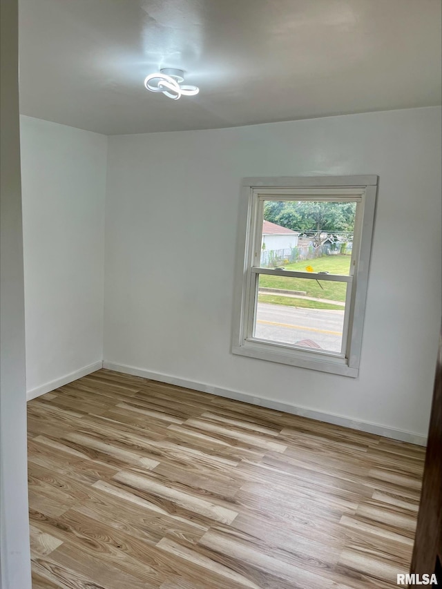 spare room with light wood finished floors and baseboards