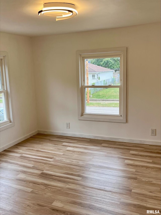unfurnished room featuring light wood finished floors and baseboards