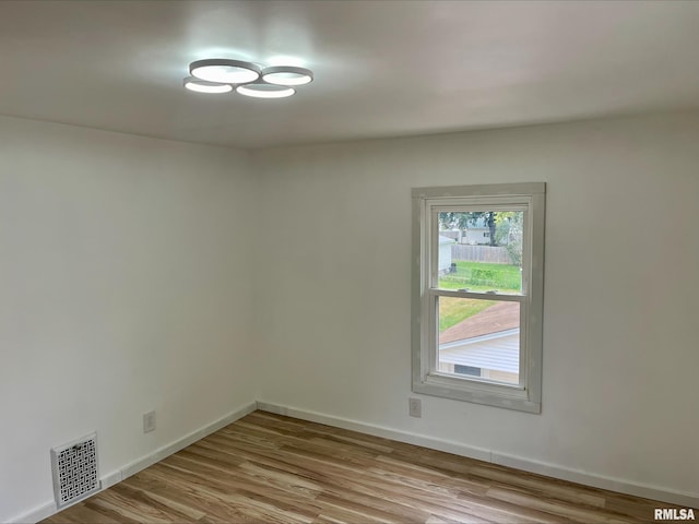 spare room featuring visible vents, wood finished floors, and baseboards