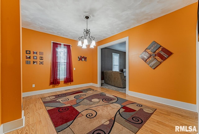 foyer entrance featuring wood-type flooring and a chandelier