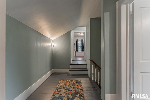 staircase featuring wood-type flooring and vaulted ceiling