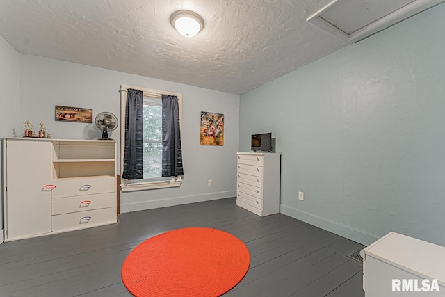 interior space featuring a textured ceiling and dark wood-type flooring