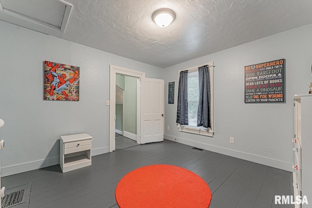 interior space with a textured ceiling and dark wood-type flooring