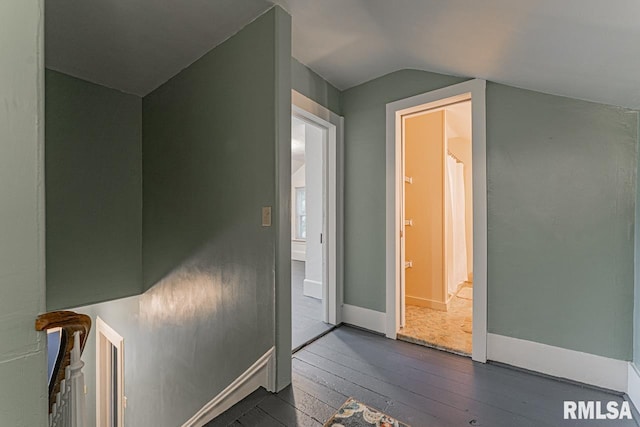 hallway with lofted ceiling and dark hardwood / wood-style floors