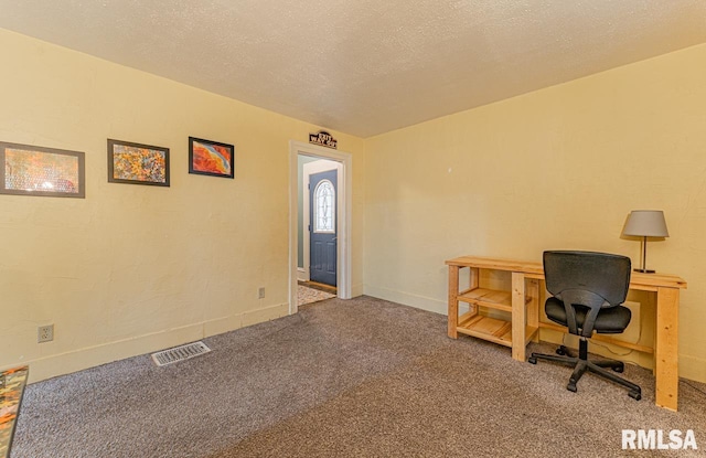 carpeted office space featuring a textured ceiling