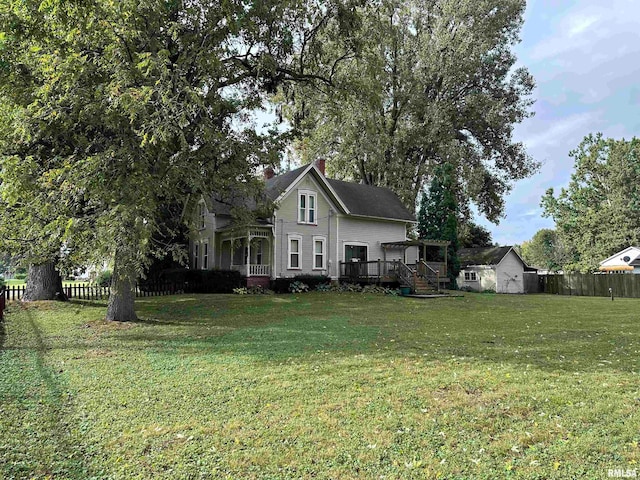 view of front facade with a storage unit, a front yard, and a deck