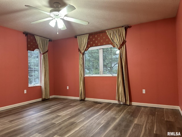 empty room with ceiling fan, plenty of natural light, a textured ceiling, and hardwood / wood-style flooring