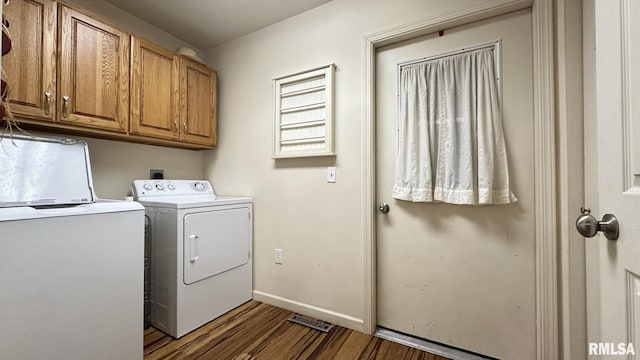 clothes washing area with cabinets, independent washer and dryer, and dark wood-type flooring