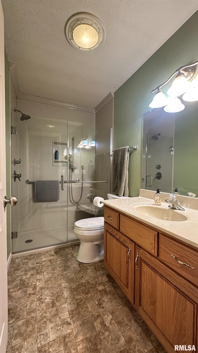 bathroom featuring vanity, a textured ceiling, toilet, and walk in shower