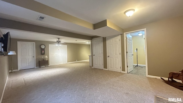 basement featuring ceiling fan and light carpet