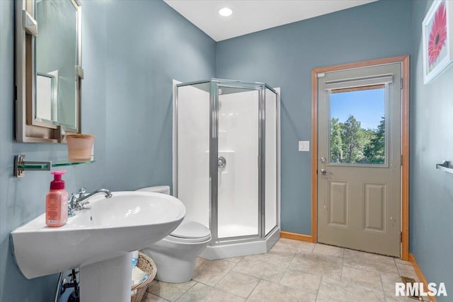 bathroom with toilet, a shower with door, and tile patterned floors