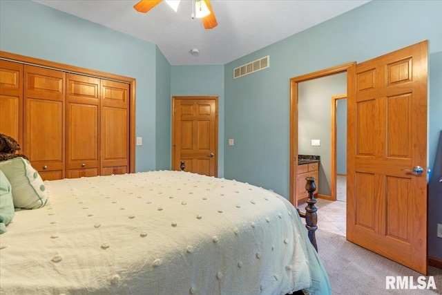 bedroom featuring ceiling fan, light colored carpet, and a closet