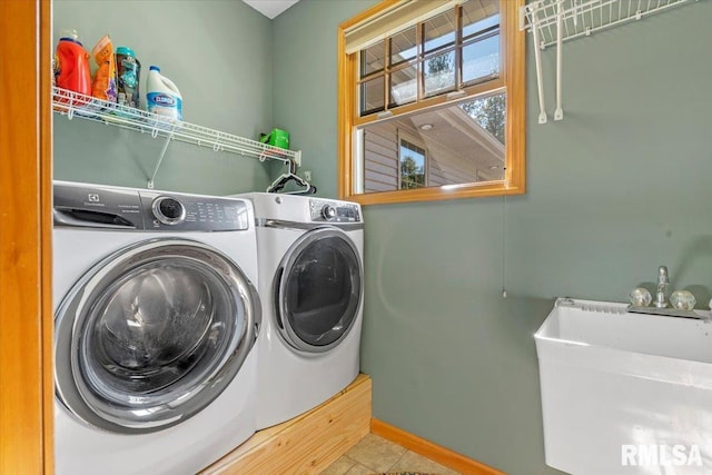 washroom with washing machine and clothes dryer, tile patterned flooring, and sink