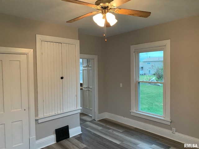 empty room with ceiling fan and dark wood-type flooring