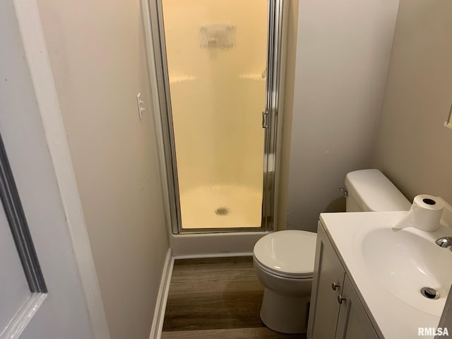 bathroom with toilet, a shower with door, vanity, and hardwood / wood-style flooring