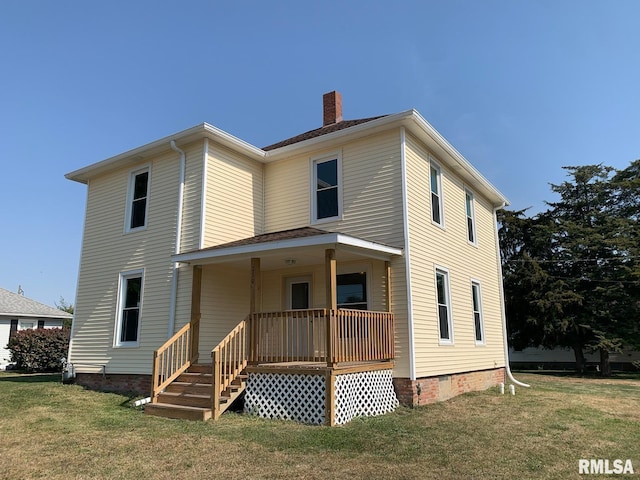 rear view of house featuring a porch and a yard