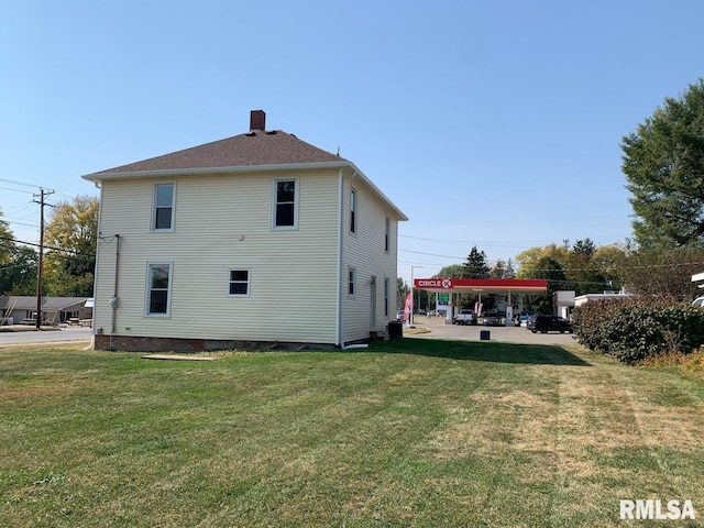 back of property featuring a yard and central air condition unit