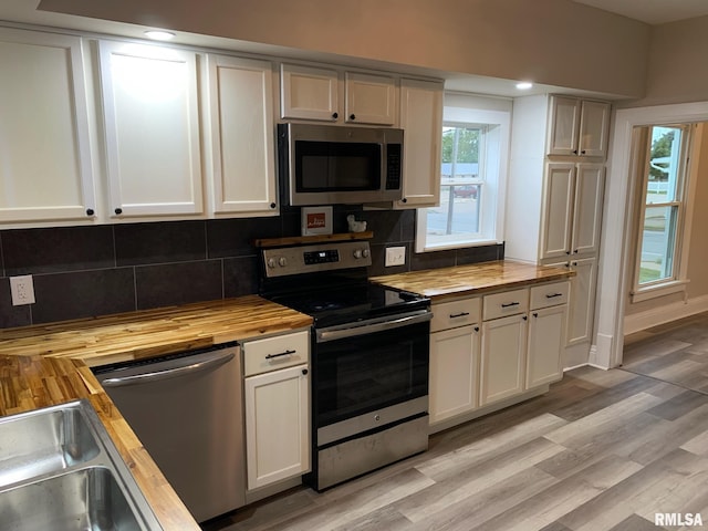 kitchen featuring butcher block countertops, white cabinets, and appliances with stainless steel finishes