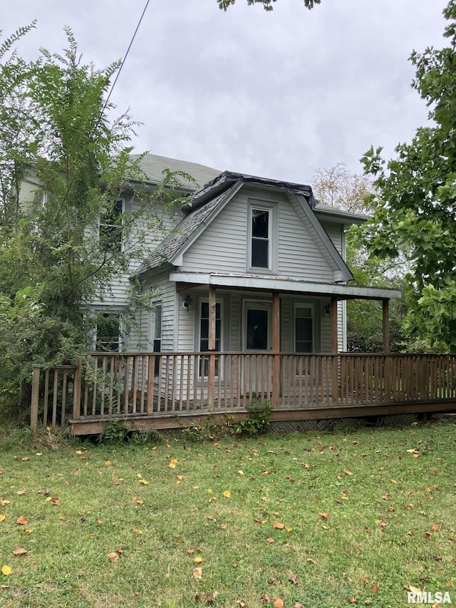 view of front of property with a wooden deck and a front lawn