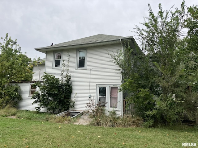 rear view of property featuring a lawn