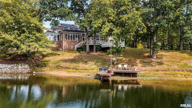 view of dock with a yard and a deck with water view