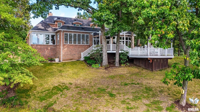 rear view of property featuring a wooden deck and a yard