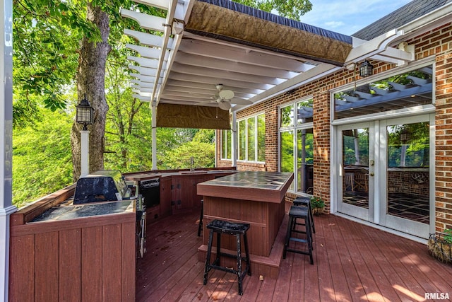 deck with ceiling fan, a wet bar, and a grill