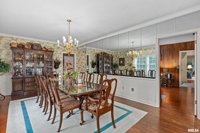 dining space with wood-type flooring, ornamental molding, and a chandelier