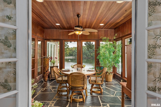 dining room featuring wood ceiling, a water view, ceiling fan, and french doors