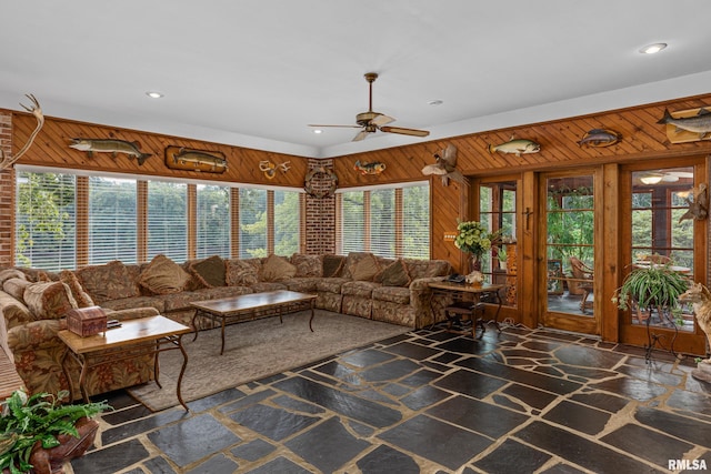 unfurnished living room with wood walls and ceiling fan