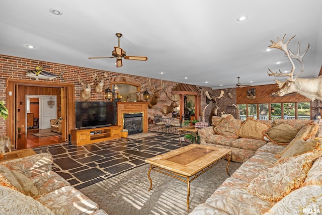 living room featuring ceiling fan and brick wall