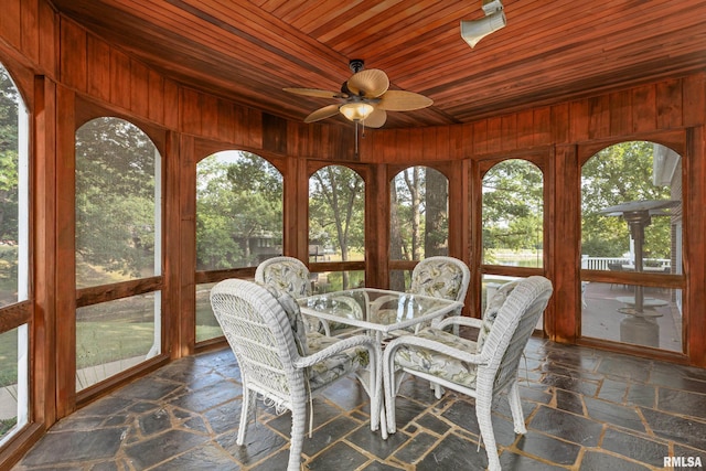 unfurnished sunroom with wooden ceiling, ceiling fan, and a wealth of natural light