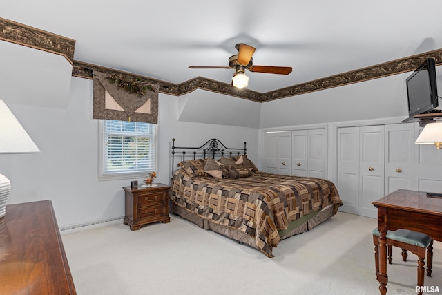 carpeted bedroom featuring two closets, a baseboard heating unit, and ceiling fan