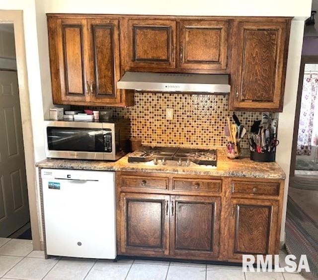 kitchen with backsplash, light tile patterned floors, stainless steel appliances, and range hood