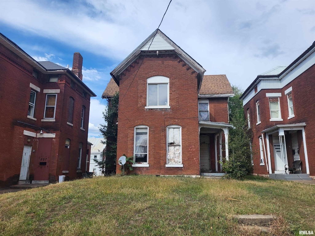 view of front of property with a front lawn and brick siding